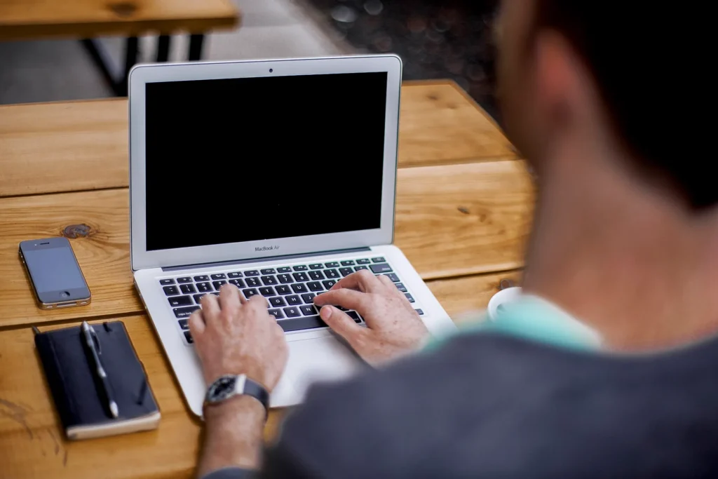 Persona escribiendo en su laptop para enviar documentos de su placa temporal por correo electrónico
