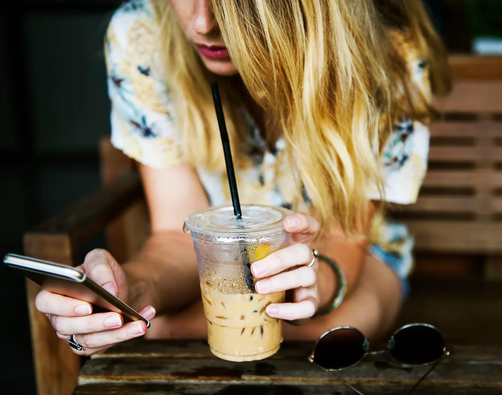 Mujer escribiendo en su celular para hablar con un asesor de placas temporales por WhatsApp