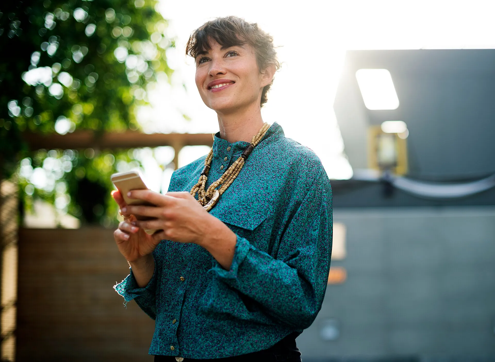 Mujer sonriendo mientras usa su celular