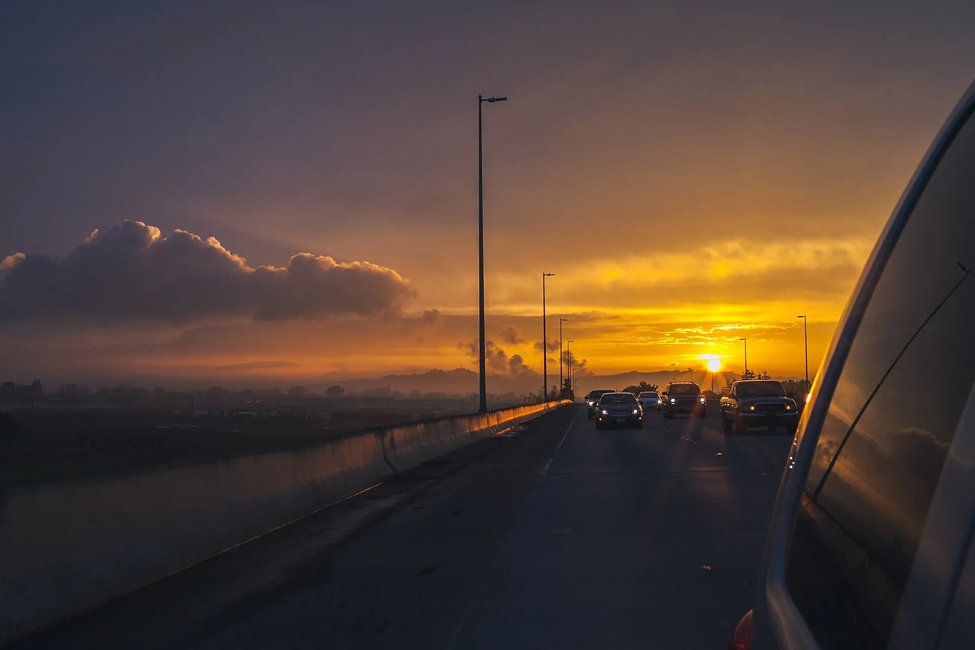 Carros circulando por una autopista al atardecer