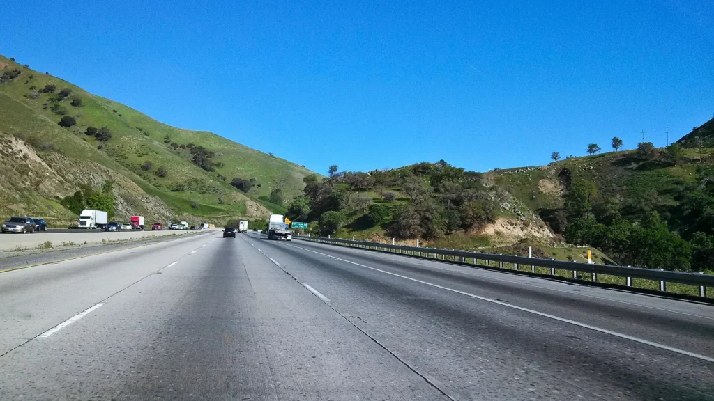 Interstate 5 cruzando las colinas verdes cerca de Fort Tejon, ruta del Grapevine para manejar con placa temporal en California