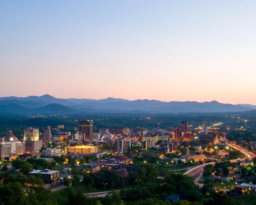 Vista de Asheville al atardecer con las montañas Blue Ridge al fondo, zona oeste donde también llega nuestra placa temporal en Carolina del Norte