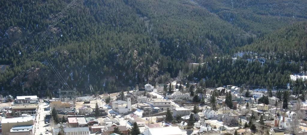 Pueblo de Georgetown en un valle con nieve visto desde la I-70, tramo de montaña para manejar con placa temporal en Colorado