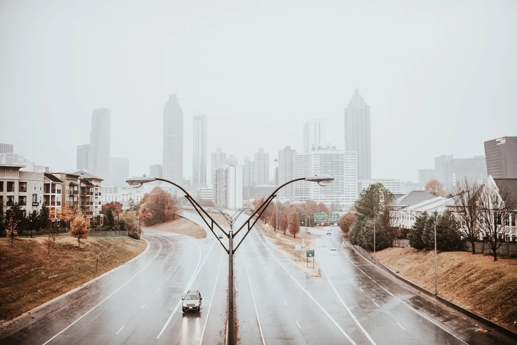 Avenida de varios carriles que entra al centro de Atlanta en un día nublado, ruta habitual con placa temporal en Georgia hacia la revisión de emisiones