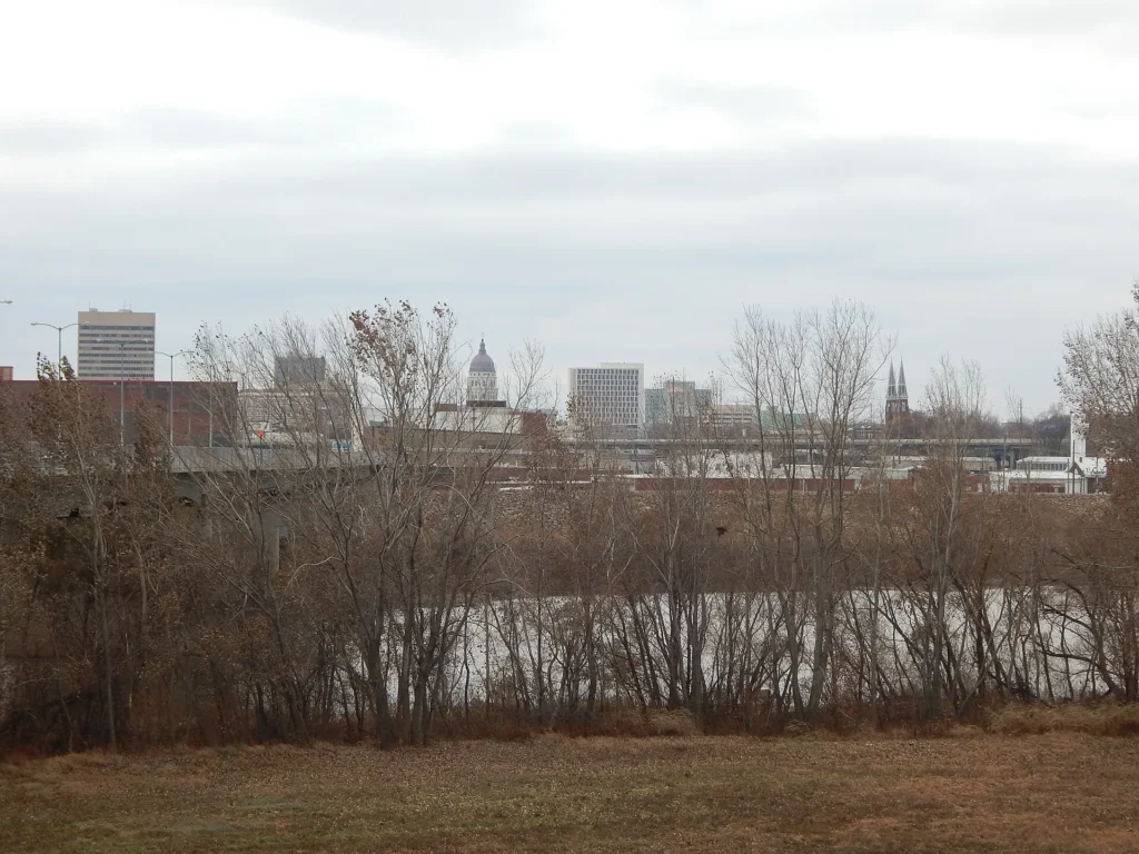 Vista del centro de Topeka con el río Kansas en primer plano, ciudad capital donde se decide la placa temporal en Kansas y los registros del estado