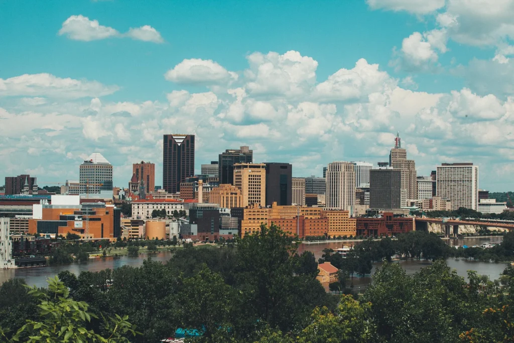 Skyline de Saint Paul con el río Mississippi y nubes de verano, capital donde el DVS procesa los títulos de quien pide placa temporal en Minnesota