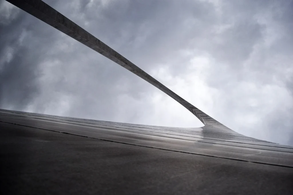 Gateway Arch de St. Louis visto desde su base contra un cielo nublado, símbolo de Misuri y de la ciudad donde entregamos placa temporal en Misuri