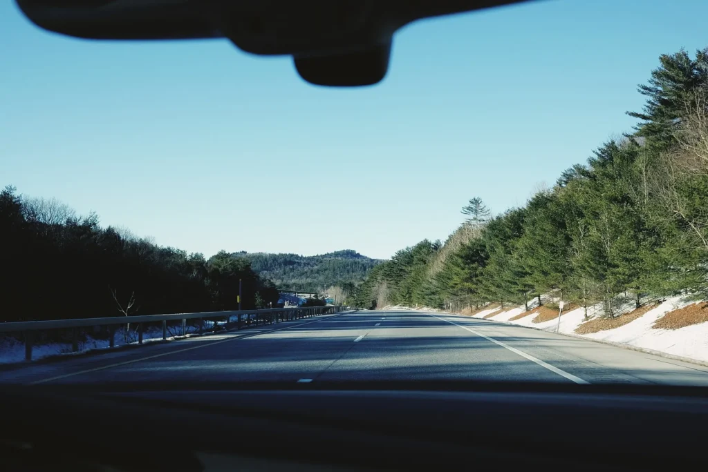 Carretera de montaña con nieve en las orillas cerca de Catskill, vista desde dentro del carro