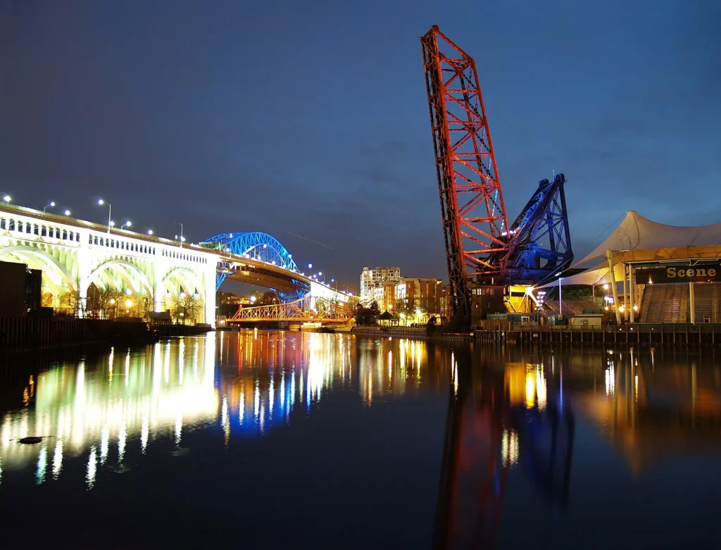 Puente levadizo iluminado de noche sobre el río Cuyahoga en los Flats de Cleveland, ciudad del noreste de Ohio donde emitimos placa temporal en Ohio con E-Check