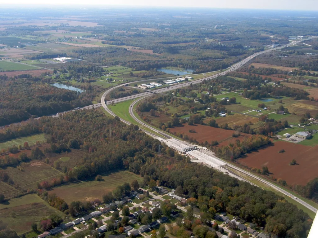 Vista aérea de un intercambio del Ohio Turnpike entre campos de cultivo del norte de Ohio, autopista por la que se circula con permiso temporal para circular en Ohio