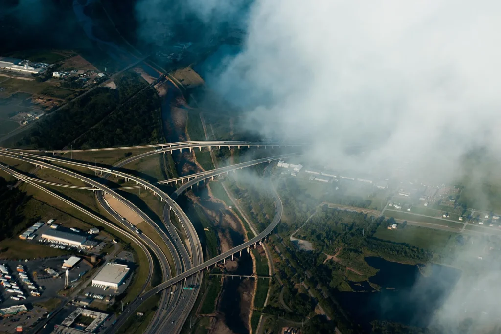 Vista aérea de un cruce de autopistas en Oklahoma City entre nubes bajas, nudo de la I-35, la I-40 y la I-44 para rodar con placa temporal en Oklahoma