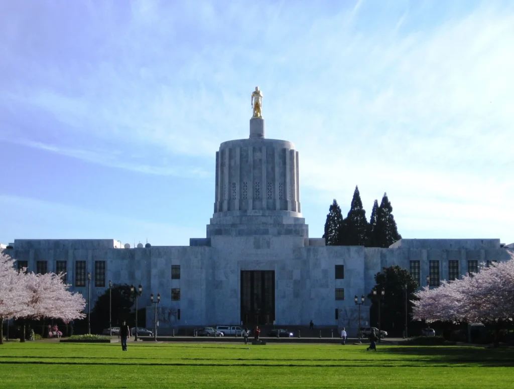 Fachada del Capitolio de Oregón en Salem con su estatua dorada, ciudad sede del DMV estatal que titula y registra carros con placa temporal en Oregón