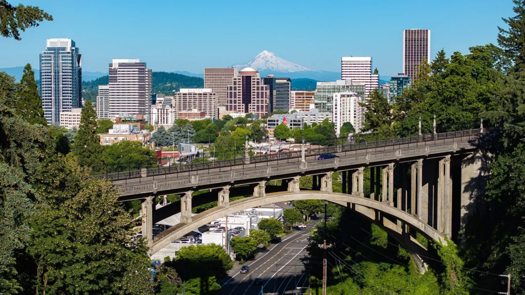 Vista aérea de Portland con el río Willamette, las autopistas y el Monte Hood al fondo, la ciudad donde más se pide placa temporal en Oregón