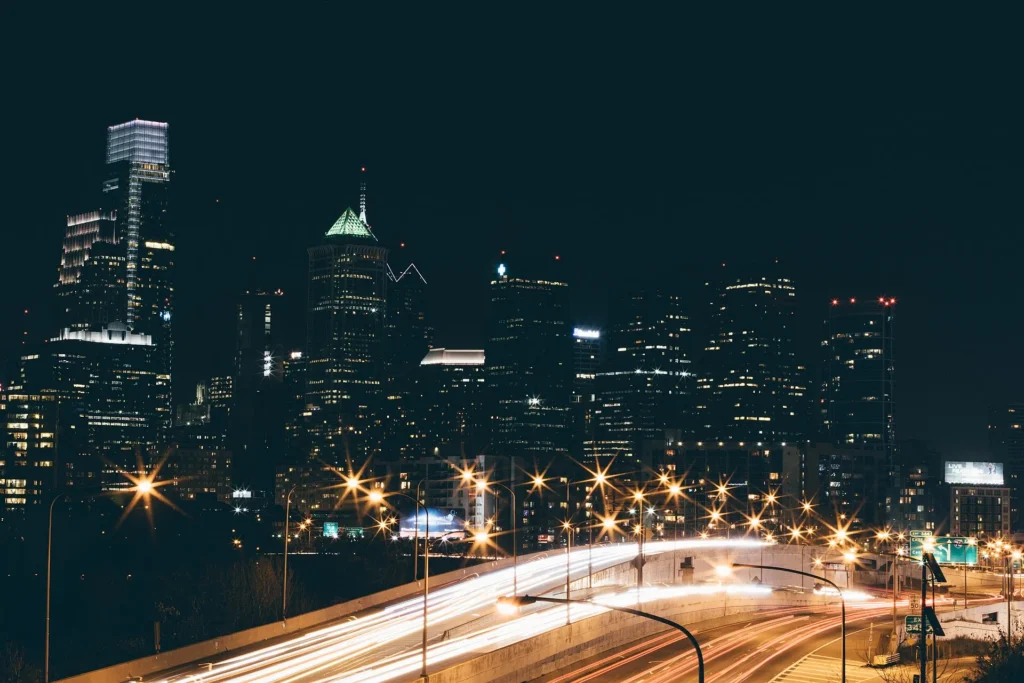 Rascacielos de Filadelfia al atardecer con estelas de luces de la autopista, ciudad donde más se pide placa temporal en Pensilvania