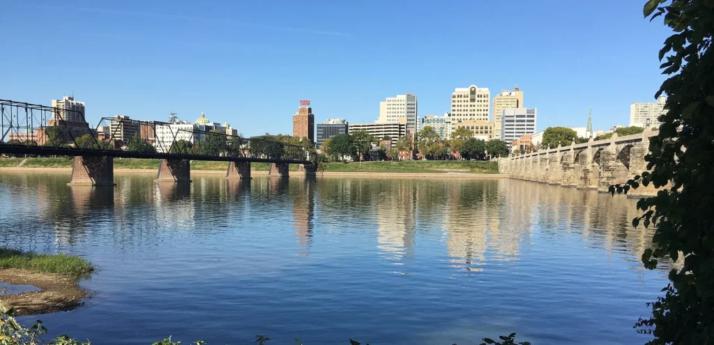 Capitolio de Pensilvania y edificios de Harrisburg vistos desde City Island sobre el río Susquehanna, capital donde PennDOT fija las reglas de la placa temporal en Pensilvania