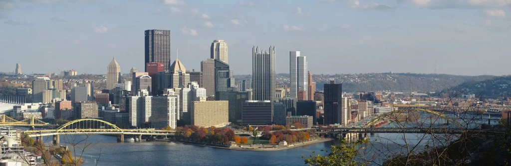 Panorámica del centro de Pittsburgh con sus puentes amarillos sobre los ríos, ciudad del oeste donde también vendemos placa temporal en Pensilvania