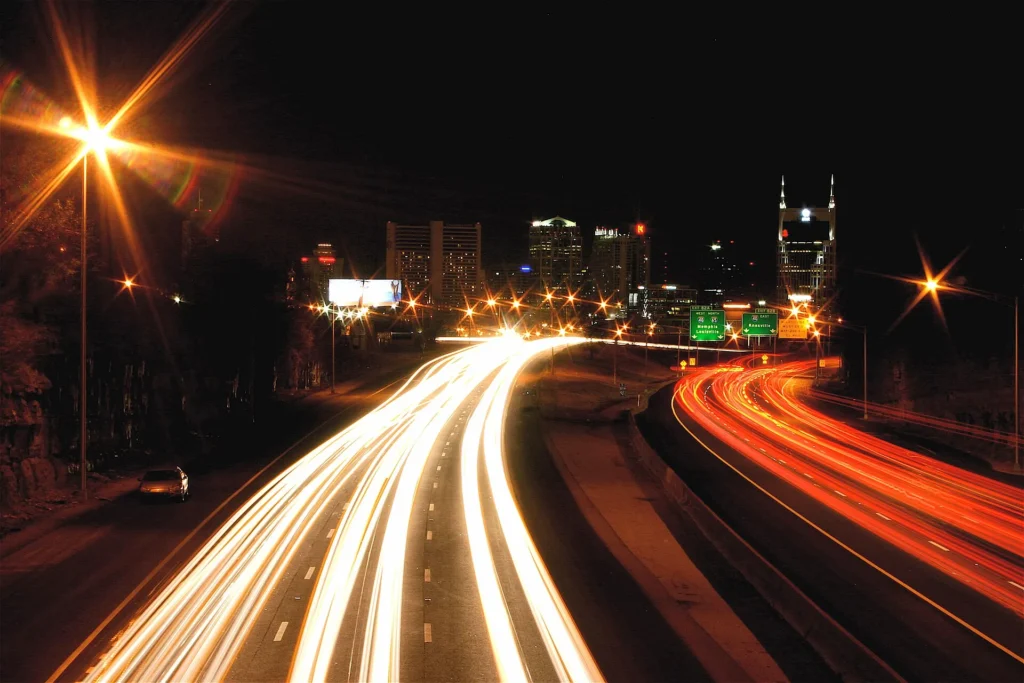 Estelas de luces de autos sobre la I-65 de noche con el centro de Nashville al fondo, tráfico típico para manejar con permiso temporal para circular en Tennessee