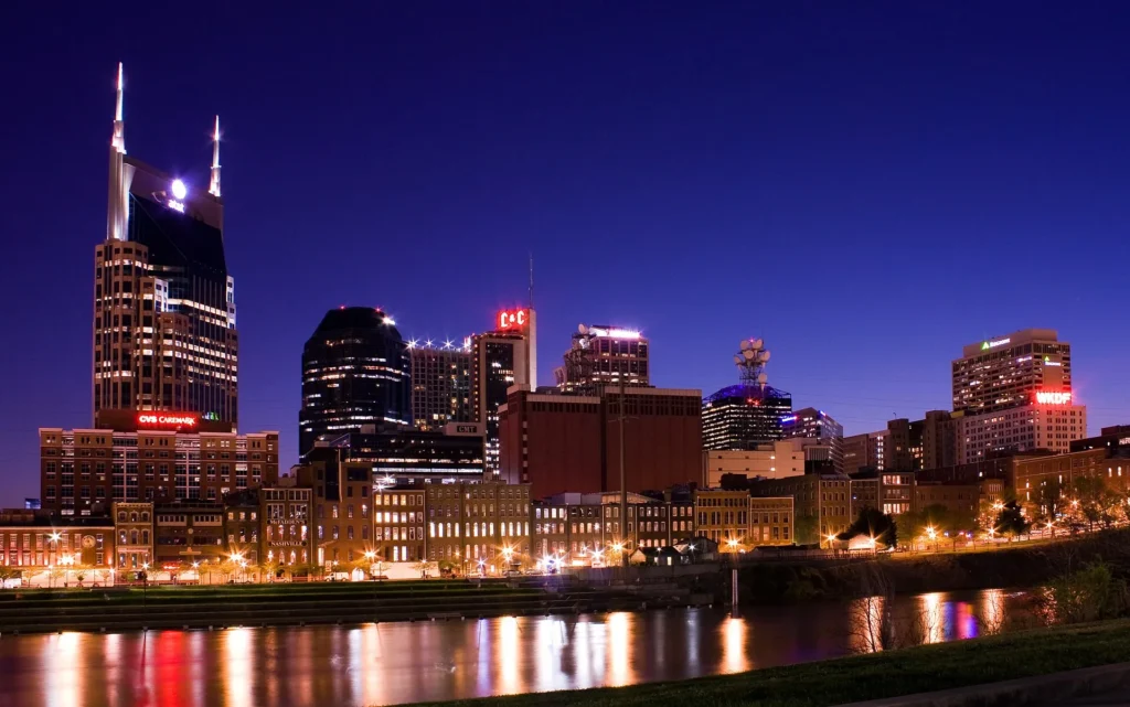 Edificios del centro de Nashville reflejados en el río Cumberland al atardecer, capital de Tennessee donde más se tramita placa temporal en Tennessee