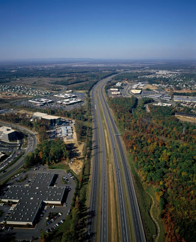 Vista aérea de los suburbios del Norte de Virginia con la autopista cruzando entre edificios y arboledas, zona donde más se pide placa temporal en Virginia