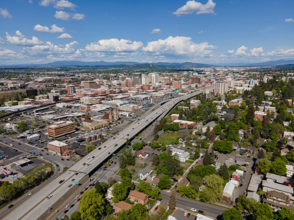 Vista aérea de Spokane con la Interstate 90 cruzando el centro, ciudad del este donde se tramita placa temporal en Washington